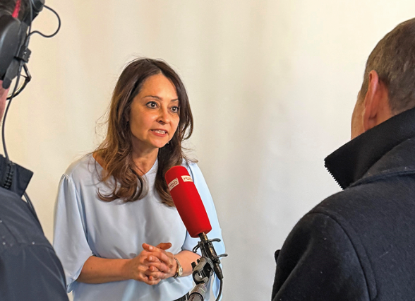 Eine Frau steht vor einem Mikrofon